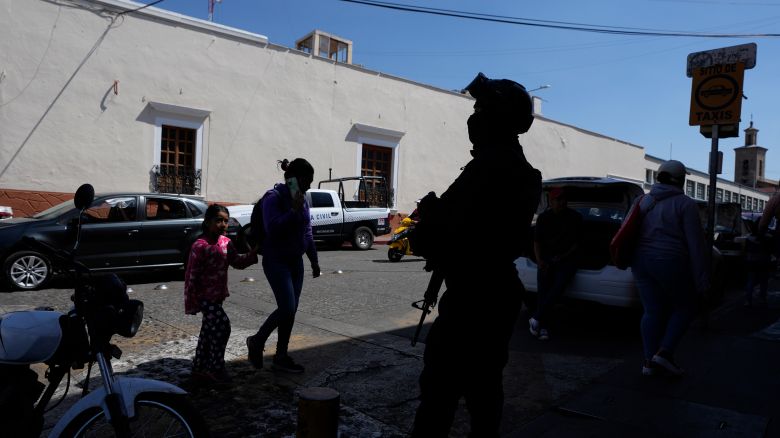A municipal police officer stands guard in Maravatio, Michoacan state, Mexico, Tuesday, Feb. 27, 2024. Two mayoral hopefuls in this city were gunned down the previous day within hours of each other, ahead of the June 2 national elections. (AP Photo/Fernando Llano)