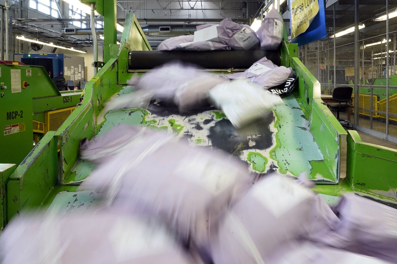 Parcels slide down a ramp after being scanned at the US Customs and Border Protection overseas mail inspection facility at Chicago's O'Hare International Airport, in February 2024