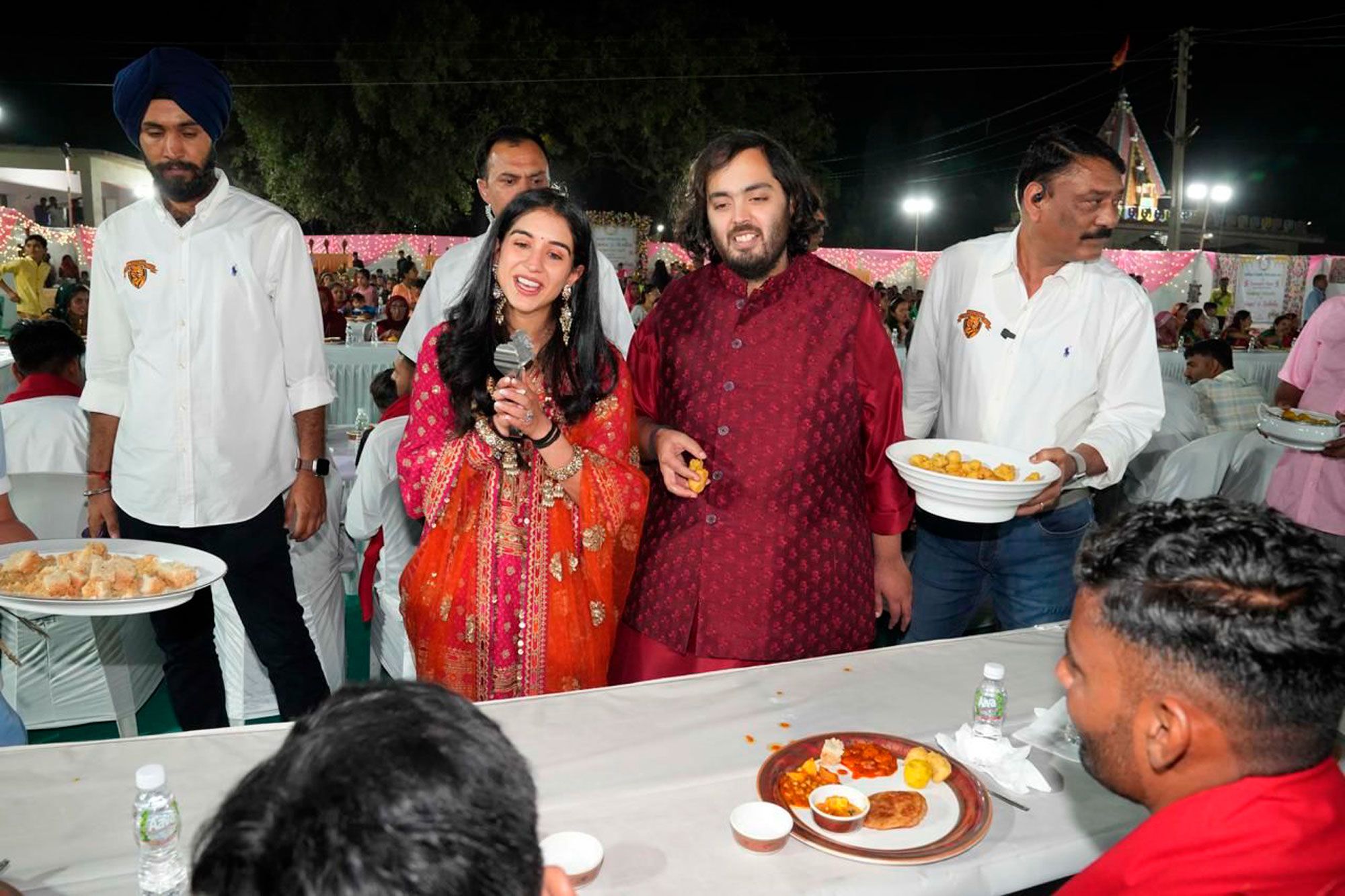 Billionaire Mukesh Ambani's son Anant and his fiancée Radhika Merchant at a pre-wedding event that served food to more than 50,000 villagers near Jamnagar, India.