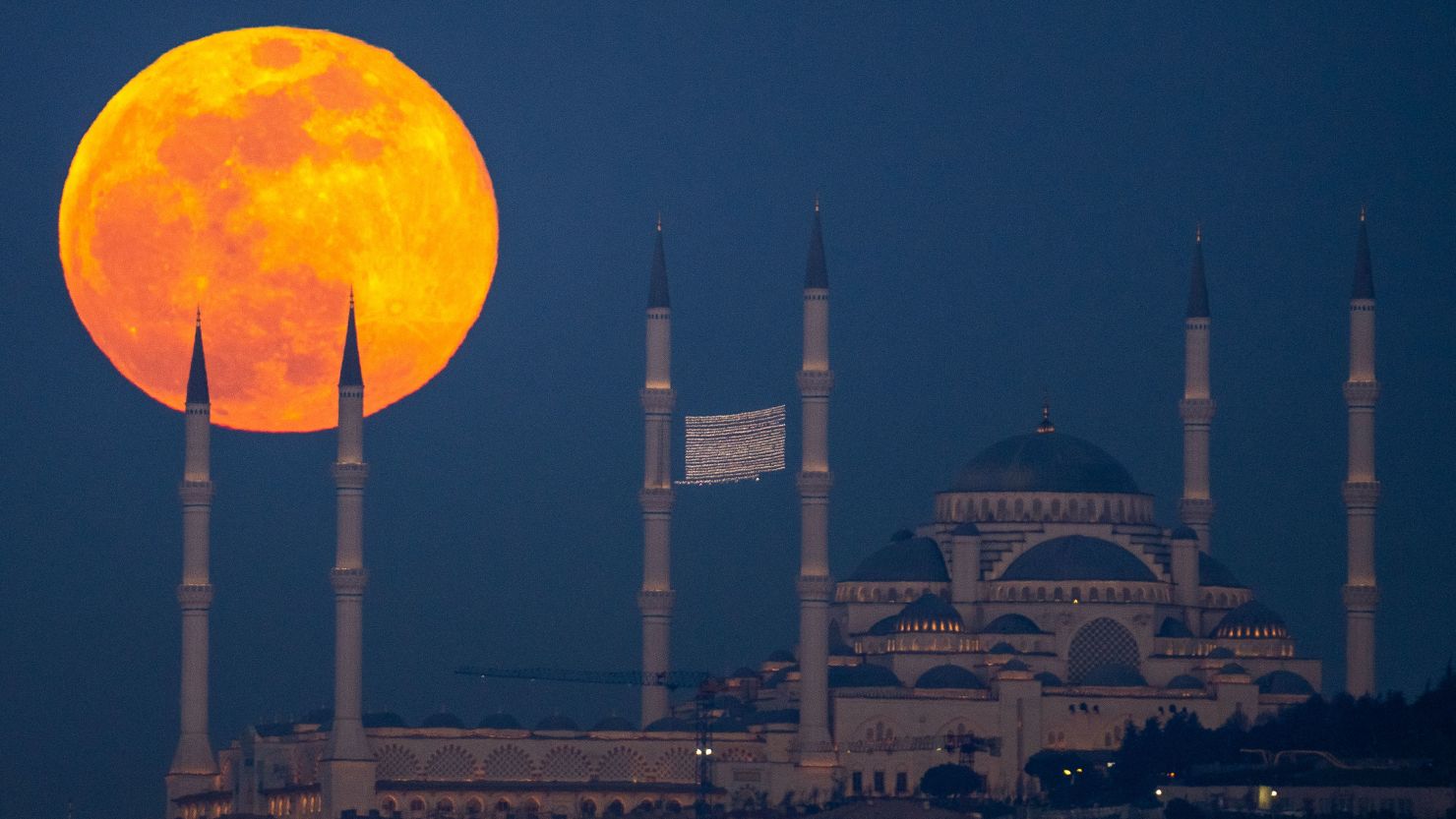 A full moon rises behind the Camlica mosque in Istanbul, Turkey, on February 24, 2024.