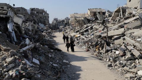 Palestinians walk through the destruction from the Israeli offensive in Jabaliya refugee camp in the Gaza Strip on Thursday, Feb. 29, 2024.