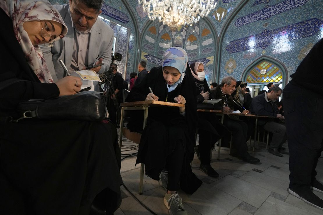Voters fill out their ballots in the parliamentary and Assembly of Experts elections at a polling station in Tehran, Iran, on Friday.