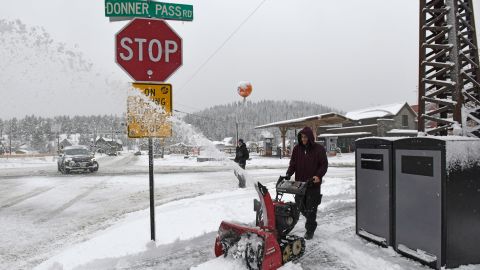 Juan Manuel plows the snow off the sidewalk in front of The Bar of American where he is employed on Friday, March 1, 2024, in downtown Truckee, Calif. The most powerful Pacific storm of the season is forecast to bring up to 10 feet of snow into the Sierra Nevada by the weekend  (AP Photo/Andy Barron)
