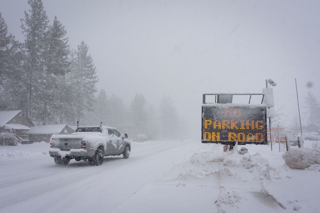 A sign warns motorists of parking restrictions as snow falls Friday in Truckee, California.