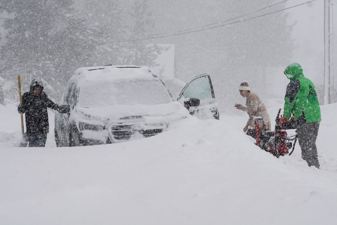 Residents try to clear snow around a car in Truckee on Saturday.