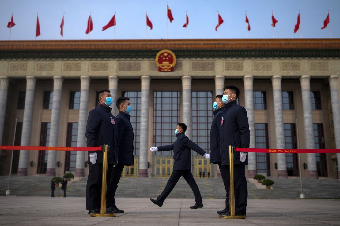 Soldiers dressed as ushers stand guard outside the Great Hall of the People ahead of the opening of the NPC in Beijing.
