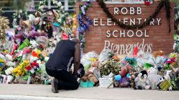 FILE - Reggie Daniels pays his respects a memorial at Robb Elementary School, June 9, 2022, in Uvalde, Texas, created to honor the victims killed in the school shooting. Nearly two years after the deadly school shooting in Uvalde that left 19 children and two teachers dead, the city council will discuss Thursday, March 7, 2024, the results of an independent investigation it requested into the response by local police officers. (AP Photo/Eric Gay, File)