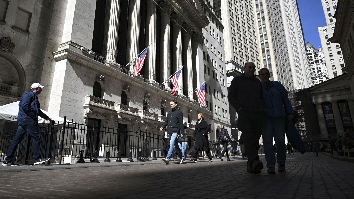 People walk past The New York Stock Exchange in the financial district of Lower Manhattan, New York City on March 8, 2024.