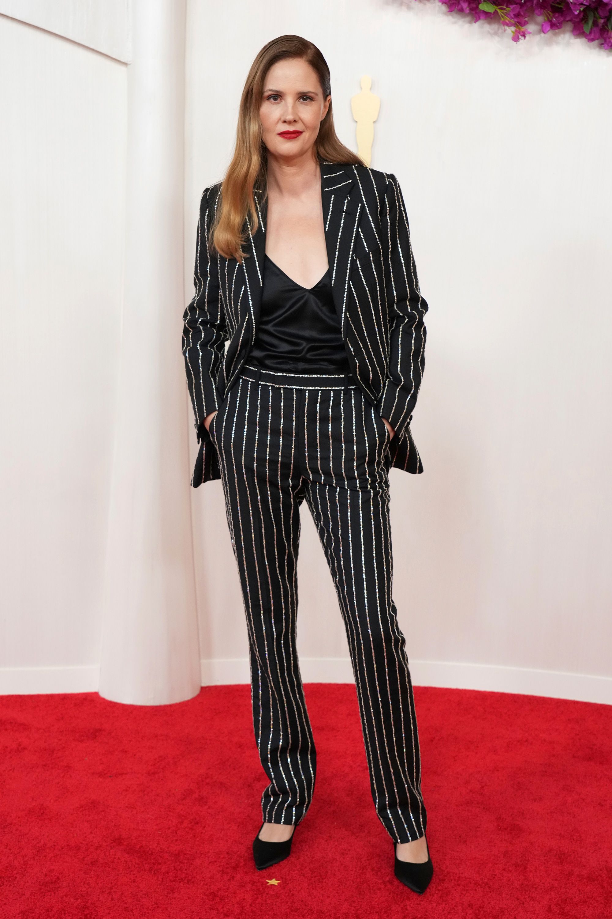 Justine Tritt, que mais tarde levou para casa o Oscar de Melhor Roteiro Original por Anatomia de uma Queda, usava um terno Louis Vuitton listrado brilhante.