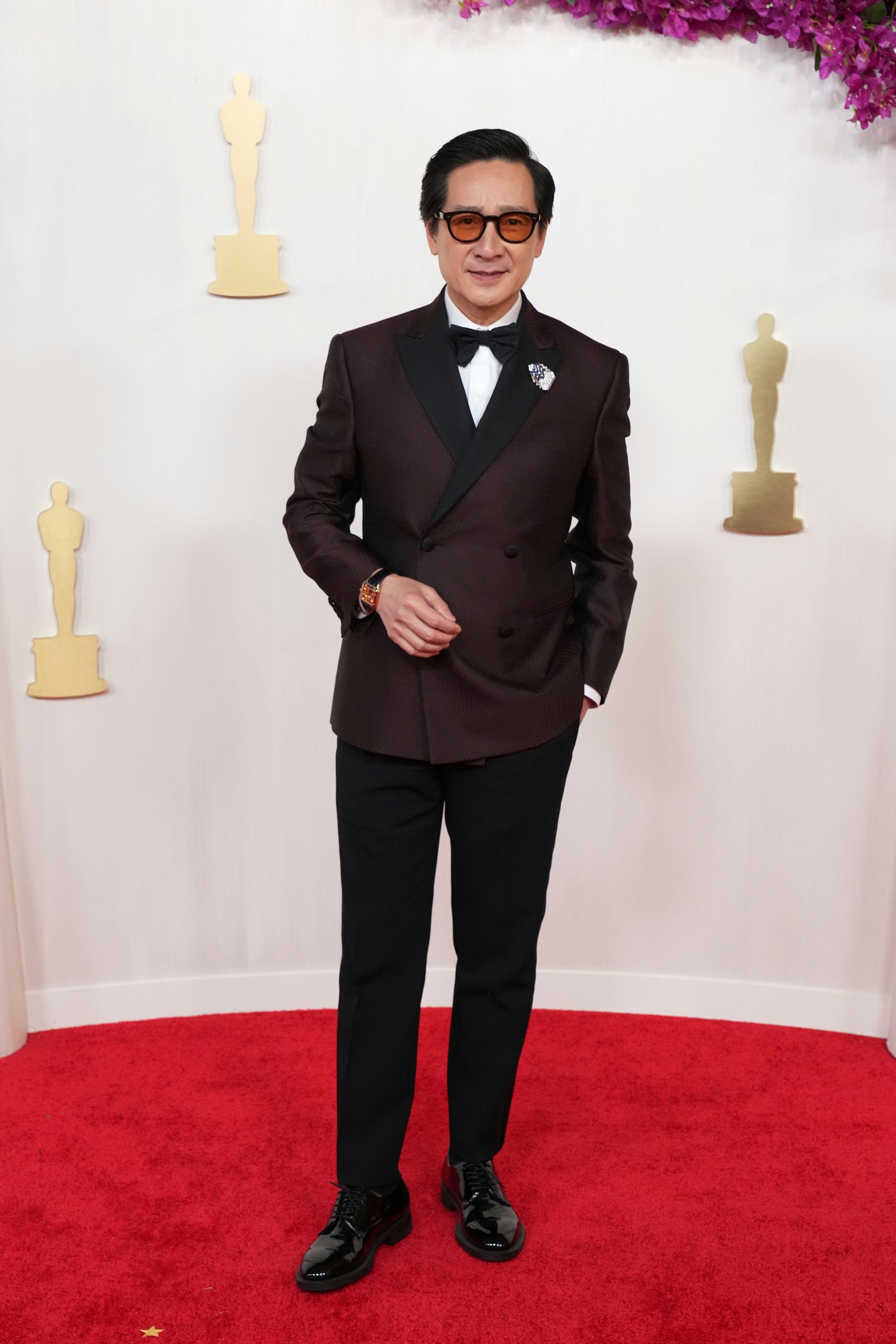 Ke Huy Quan wore a deep red double-breasted Giorgio Armani suit accented with amber shades.