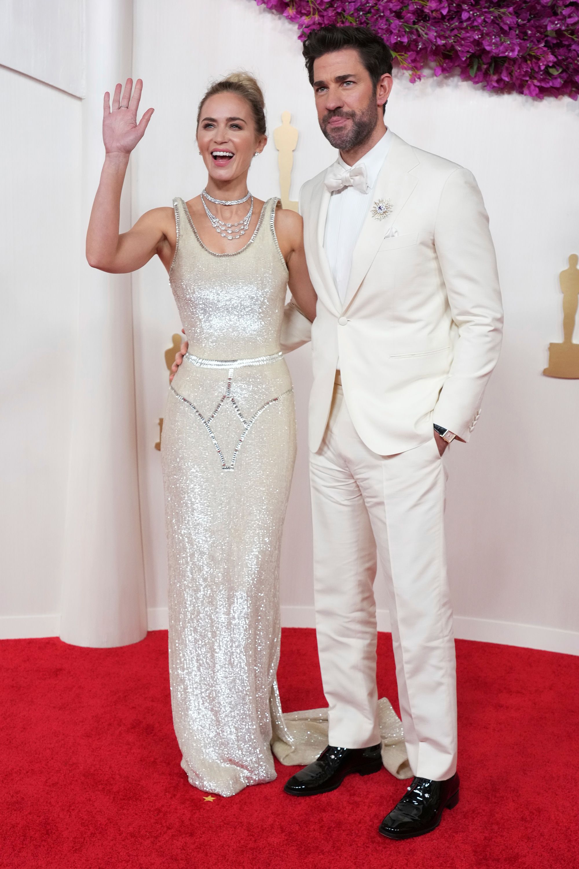 Emily Blunt wore a striking Schiaparelli dress with floating straps.  She was photographed with her husband John Krasinski in an off-white tuxedo.