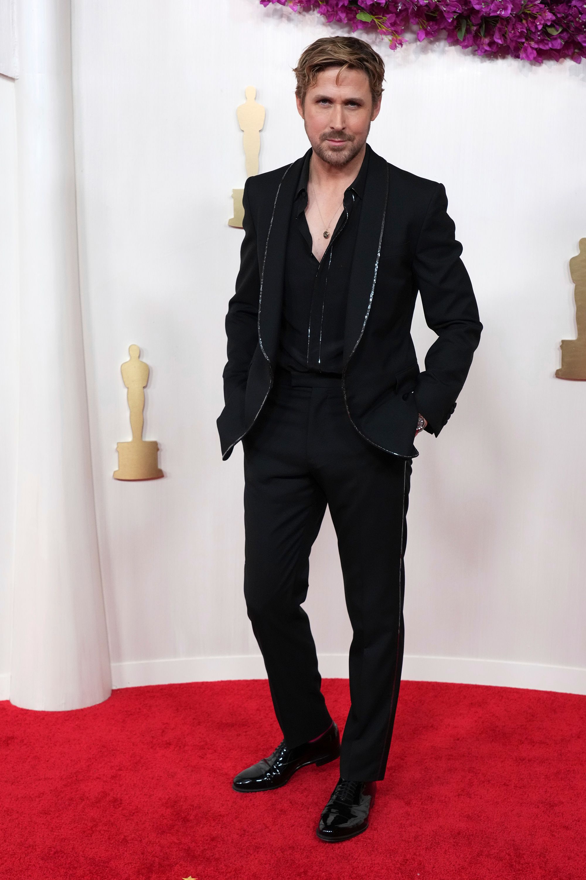 Ryan Gosling, indicado ao prêmio de Melhor Ator Coadjuvante por sua atuação em Barbie, chegou com um terno Gucci personalizado forrado com lantejoulas prateadas.
