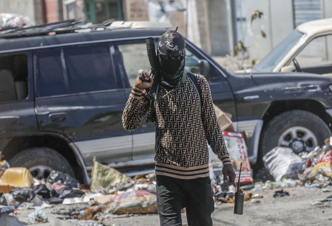 An armed member of the G9 and Family gang patrols a roadblock in Port-au-Prince on Monday.