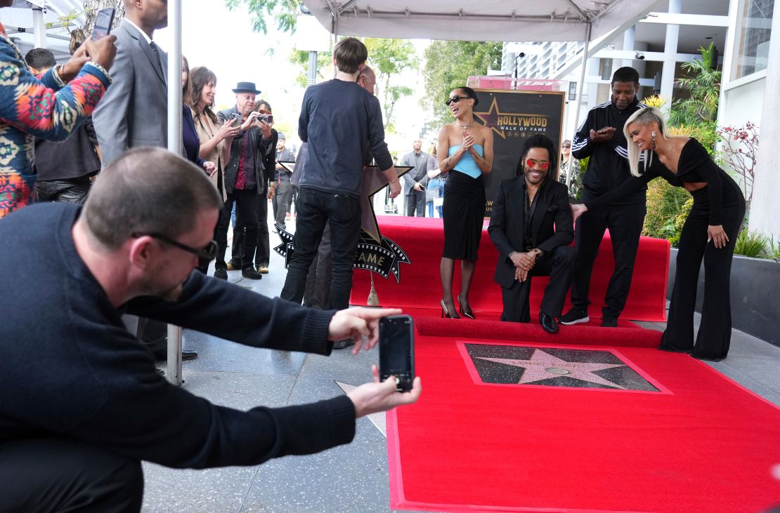 Channing Tatum, far left, takes a picture of Zoe Kravitz, from left center, Lenny Kravitz, Denzel Washington and Sibley Scoles at a ceremony honoring Lenny Kravitz with a star on the Hollywood Walk of Fame on Tuesday, March 12, 2024, in Los Angeles.