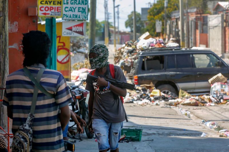 Armed members of the G9 and Family gang stand guard at their roadblock in the Delmas 6 neighborhood of Port-au-Prince, Haiti, on Monday, March 11.