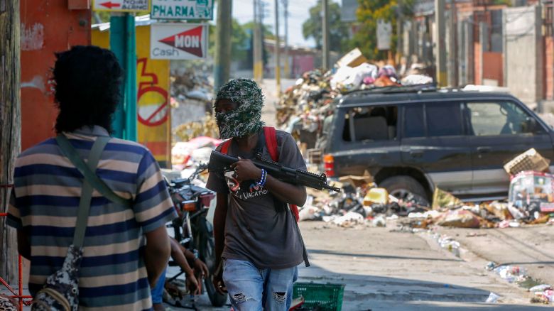 Armed members of the G9 and Family gang stand guard at their roadblock in the Delmas 6 neighborhood of Port-au-Prince, Haiti, on Monday, March 11.