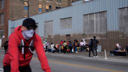 People hang around outside of a migrant shelter Wednesday, March 13, 2024, in the Pilsen neighborhood of Chicago. Multiple people living at the shelter for migrants have tested positive for measles since last week. A team from the Centers for Disease Control and Prevention is supporting local officials' response. (AP Photo/Erin Hooley)