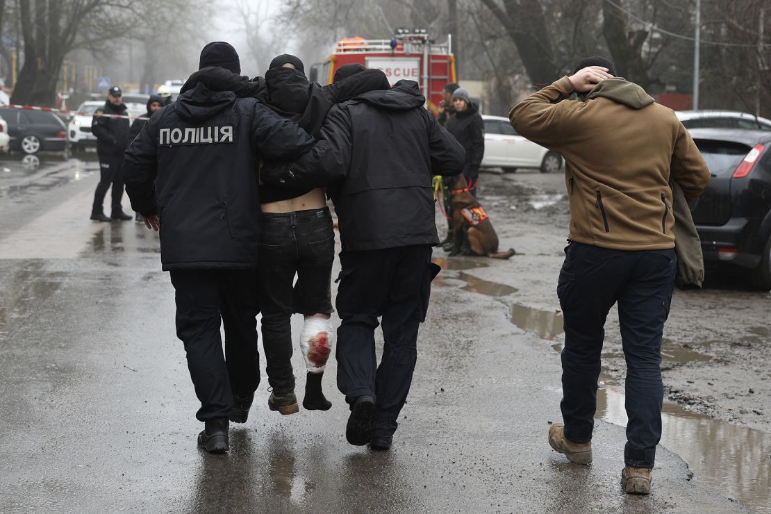 An injured man is helped away from the scene of the strike, which killed at least 14 people.