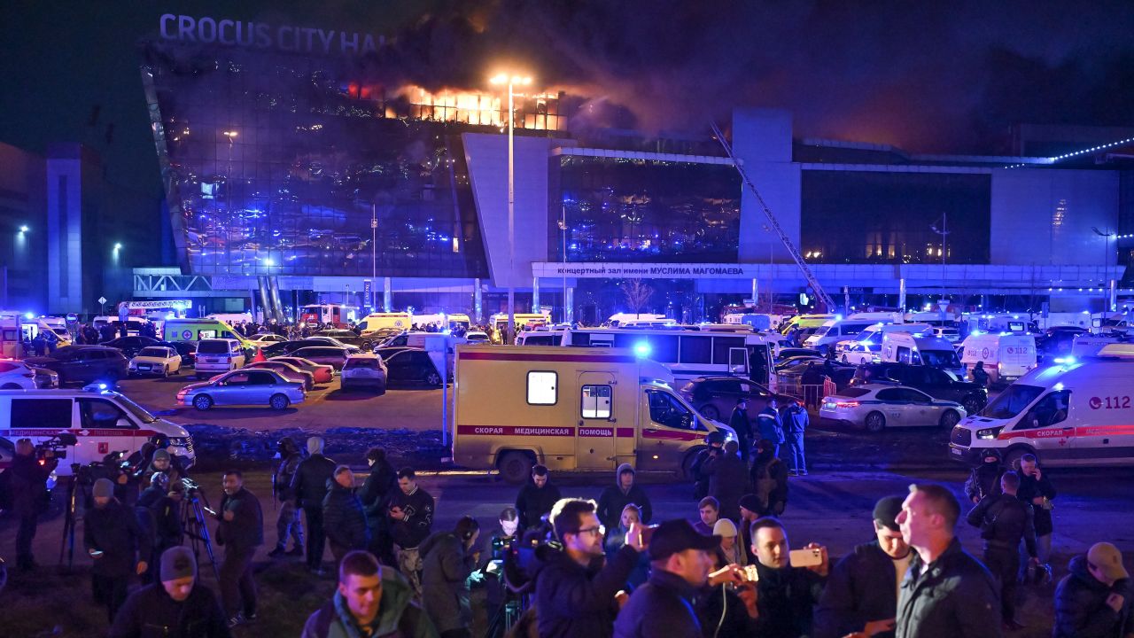 A man speaks to journalists as a massive blaze seen over the Crocus City Hall on the western edge of Moscow, Russia, Friday, March 22, 2024. Several gunmen have burst into a big concert hall in Moscow and fired automatic weapons at the crowd, injuring an unspecified number of people and setting a massive blaze in an apparent terror attack days after President Vladimir Putin cemented his grip on the country in a highly orchestrated electoral landslide.