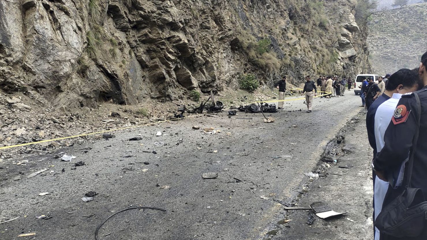 Police officers examine the site of a suicide bomb blast that killed five Chinese nationals and their Pakistani driver in northwest Pakistan on March 26, 2024.