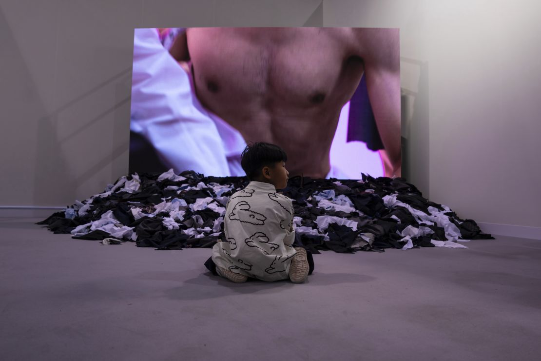 A child sits in front of Japanese artist Fuyuhiko Takata's video work "Cut Suits."