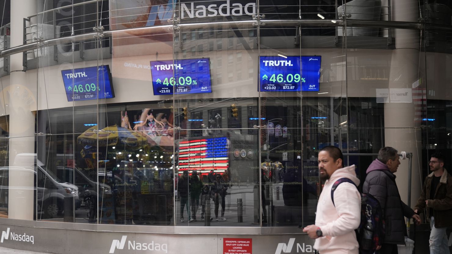 Pedestrians walk past the Nasdaq building Tuesday, March 26, 2024, in New York. Anyone who bought Trump Media at the closing high of $66.22 on March 27 has now lost more than half of their money.