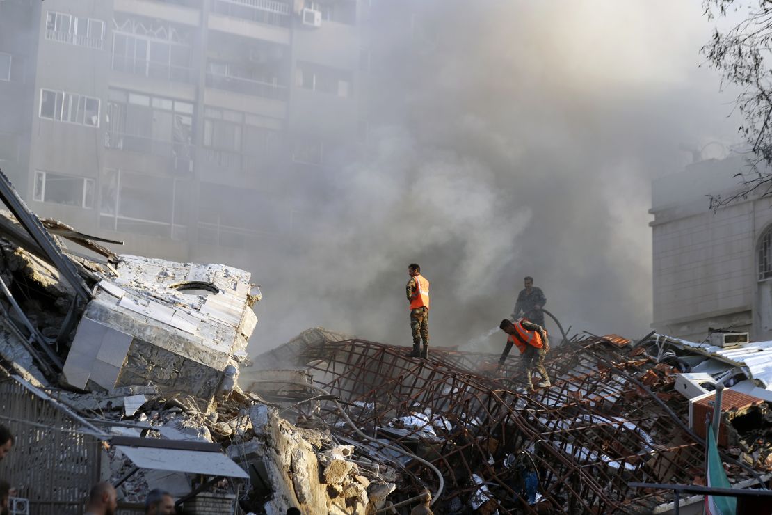 Emergency services work at a destroyed building hit by an air strike in Damascus, Syria, on April 1, 2024.