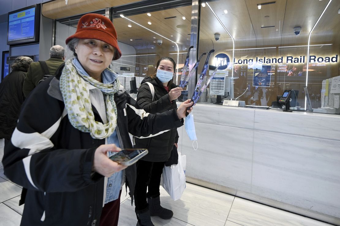 Michelle Eng and Pichnaieu Chung show of their free pairs of solar eclipse glasses after picking them up at the MTA Long Island Rail Road ticket window inside the Moynihan Train Hall, New York, NY, April 1, 2024. The solar eclipse is scheduled to occur on April 8th, 2024.