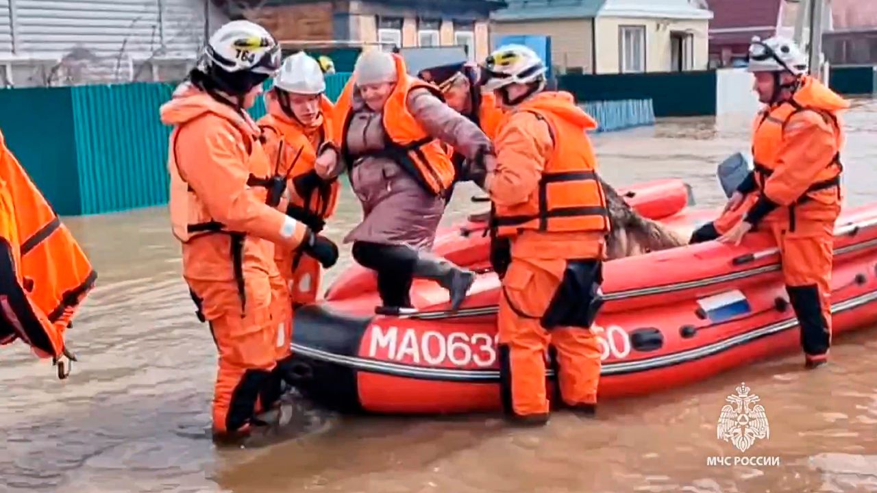 Emergency workers evacuate a local resident after a part of a dam burst causing flooding, in Orsk, Russia.