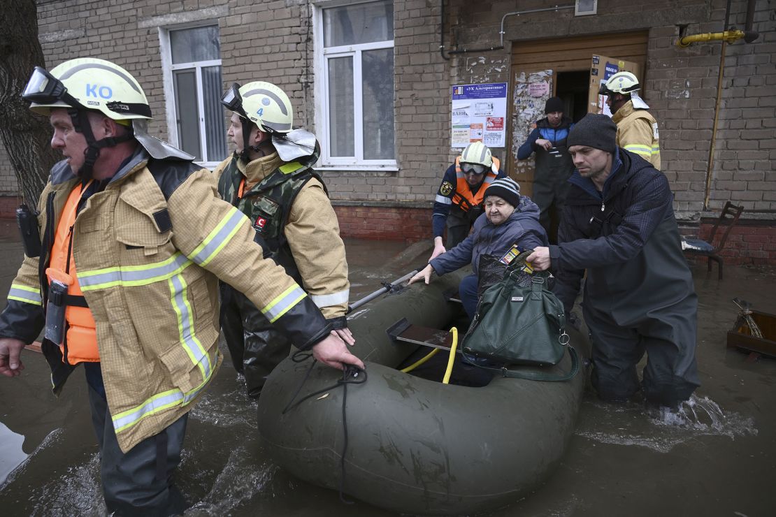 Emergency staff evacuate residents of flooded Orsk, following a dam breach in the city.