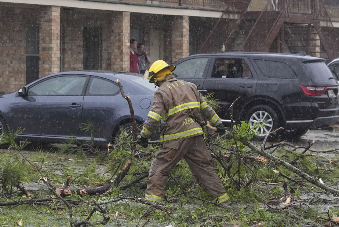 A firefighter clears debris left in the aftermath of storms in Slidell, Louisiana.