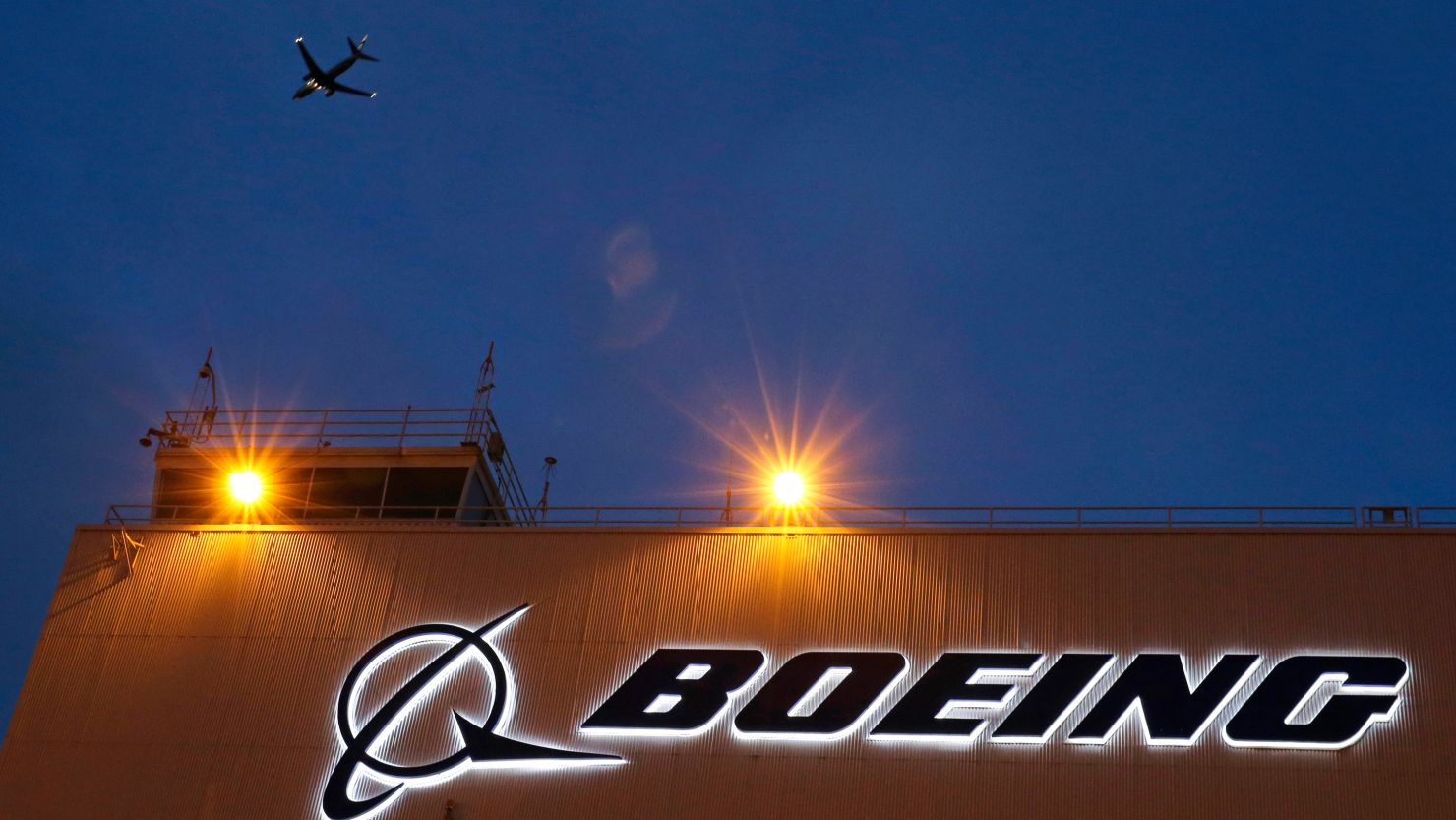 An airplane flies over a sign on Boeing's 737 delivery center, Oct. 19, 2015, at Boeing Field in Seattle.