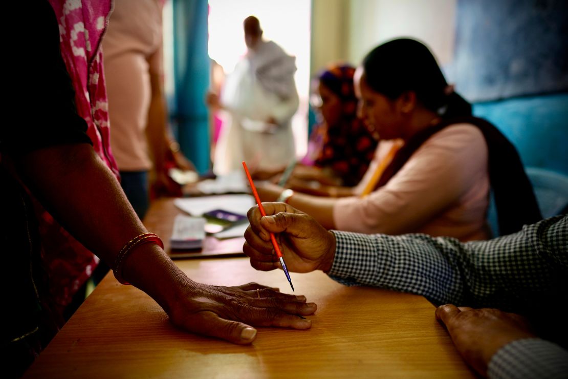 An official in Neemrana, India, paints a mark on the index finger of a woman with indelible ink before she casts her vote during the first round of polling in India's national election.