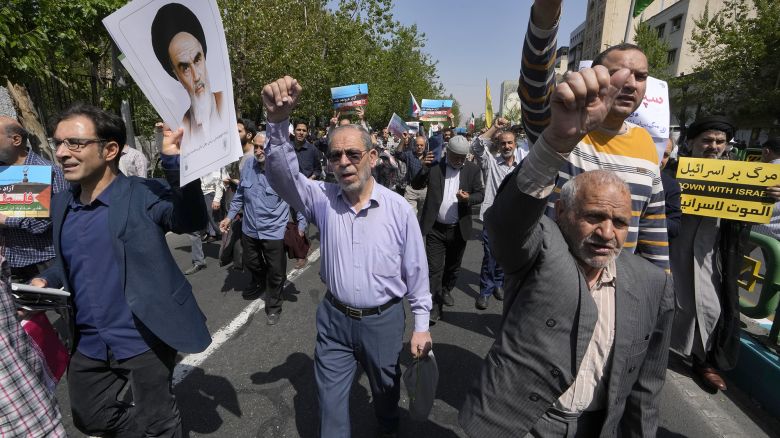 Iranian worshippers chant slogans as they hold a poster of the late revolutionary founder Ayatollah Khomeini and an anti-Israeli placard during their anti-Israeli gathering after Friday prayer in Tehran, Iran, Friday, April 19, 2024. An apparent Israeli drone attack on Iran saw troops fire air defenses at a major air base and a nuclear site early Friday morning near the central city of Isfahan, an assault coming in retaliation for Tehran's unprecedented drone-and-missile assault on the country. (AP Photo/Vahid Salemi)