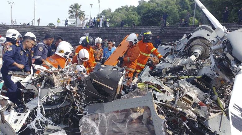 Responders inspect the helicopter crash site in Lumur, Perak state on April 23, 2024.