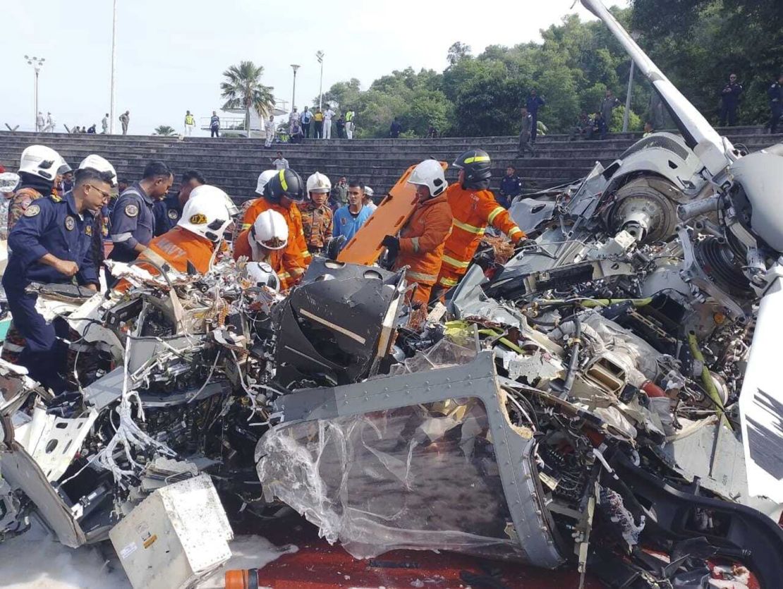 First responders inspect the helicopter crash site in Lumut, Perak state, Malaysia on April 23, 2024.