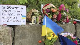 Flowers and a small Ukrainian flag are laid at a shopping center in Murnau, Germany, Sunday, April 28, 2024. Police say two Ukrainian men have been stabbed to death in southern Germany and a Russian man was arrested by authorities as a possible suspect in the killings. German news agency dpa reported Sunday that the two Ukrainians, who were 23 and 36 years old and lived in the southern German county of Garmisch-Partenkirchen, were killed on the premises of a shopping center in the village of Murnau in Upper Bavaria.