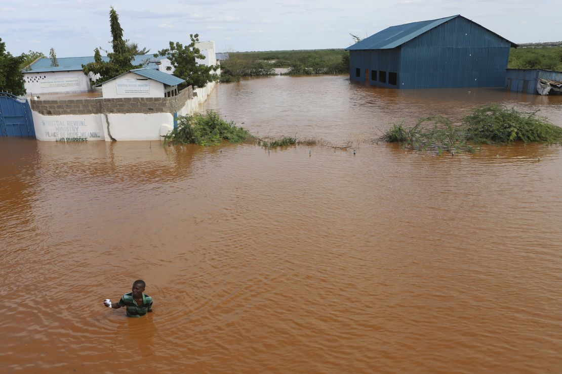 A man swims from a submerged church compound, after the River Tana broke its banks following heavy rains at Mororo, border of Tana River and Garissa counties, North Eastern Kenya, on April. 28, 2024.