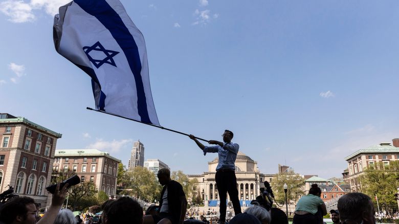 A student waves an Israeli flag outside the protest encampment on the Columbia University campus in New York City on April 29, 2024.