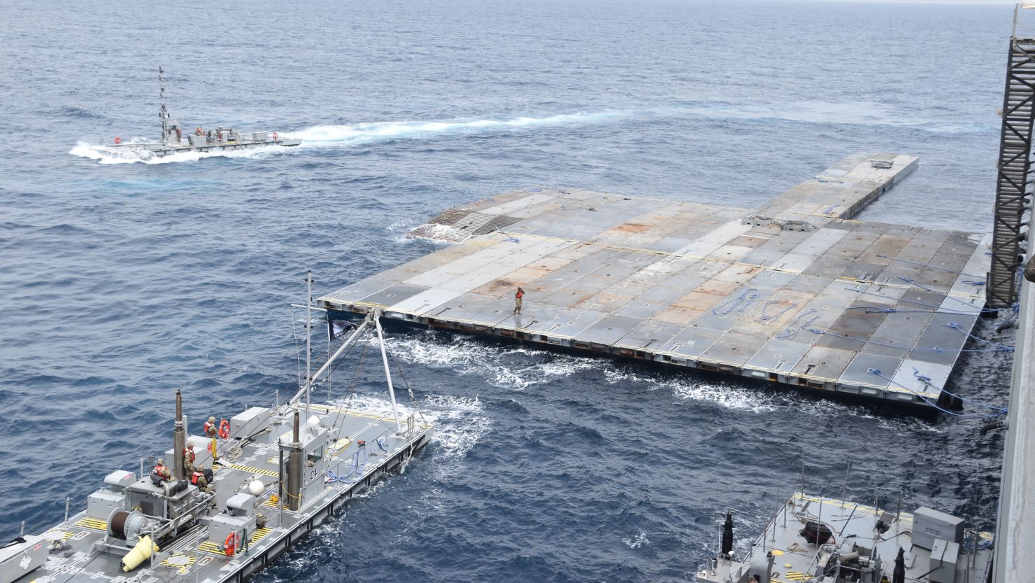 In this image provided by the US Army, soldiers assigned to the 7th Transportation Brigade (Expeditionary) and sailors attached to the M/V Roy P. Benavidez assemble the Roll-On, Roll-Off Distribution Facility (RRDF), or floating pier, off the shore of Gaza in the Mediterranean Sea on April 26, 2024. The pier is part of the Army's Joint Logistics Over The Shore (JLOTS) system which provides critical bridging and water access capabilities.