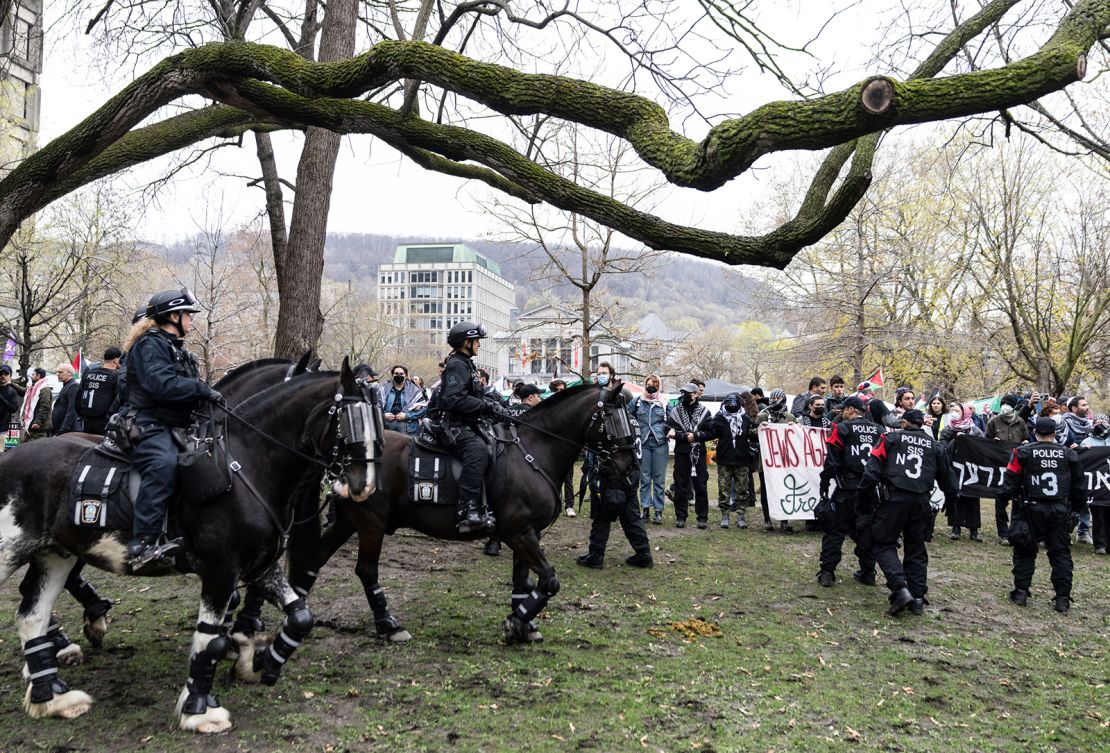 Mounted police officers walk past as pro-Palestinian activists at an encampment set up on McGill University's campus in Montreal, on May 2, 2024.