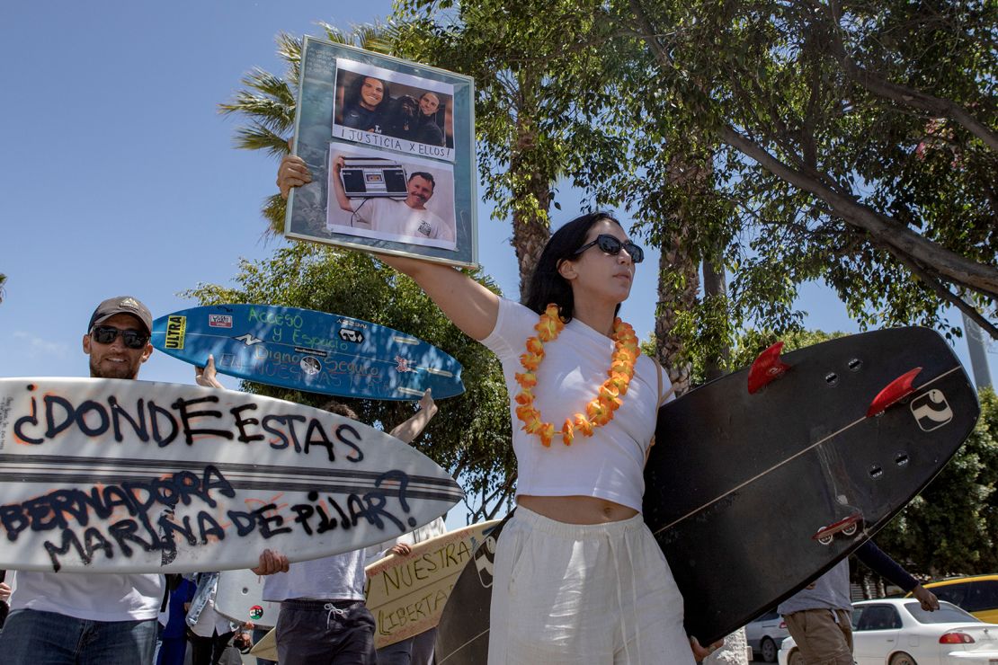 A demonstrator holds photos of the surfers during a protest in Ensenada, Mexico, on May 5, 2024.
