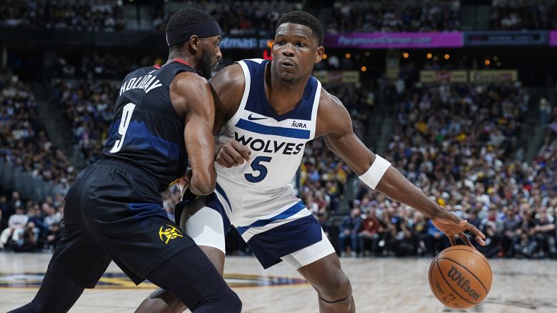 Minnesota Timberwolves guard Anthony Edwards, right, drives to the basket as Denver Nuggets forward Justin Holiday defends in the second half of Game 2 of an NBA basketball second-round playoff series Monday, May 6, 2024, in Denver. (AP Photo/David Zalubowski)