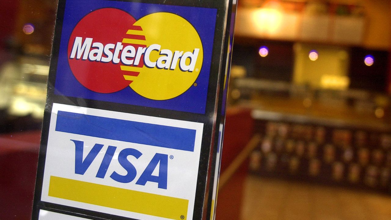 FILE - MasterCard and Visa credit card logos are shown at the entrance of a New York coffee shop, April 22, 2005. A deadline is looming for millions of businesses who may be entitled to a payout in a $5.5 billion antitrust settlement with Visa and Mastercard. The settlement stems from a 2005 lawsuit that alleged merchants paid excessive fees to accept Visa and Mastercard credit cards, and that Visa and Mastercard and their member banks acted in violation of antitrust laws. (AP Photo/Mark Lennihan, File)