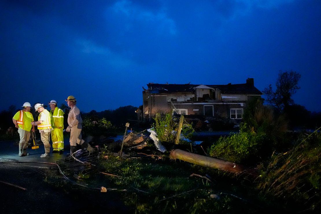 Utility workers survey storm damage along Cothran Road in Columbia, Tennessee.
