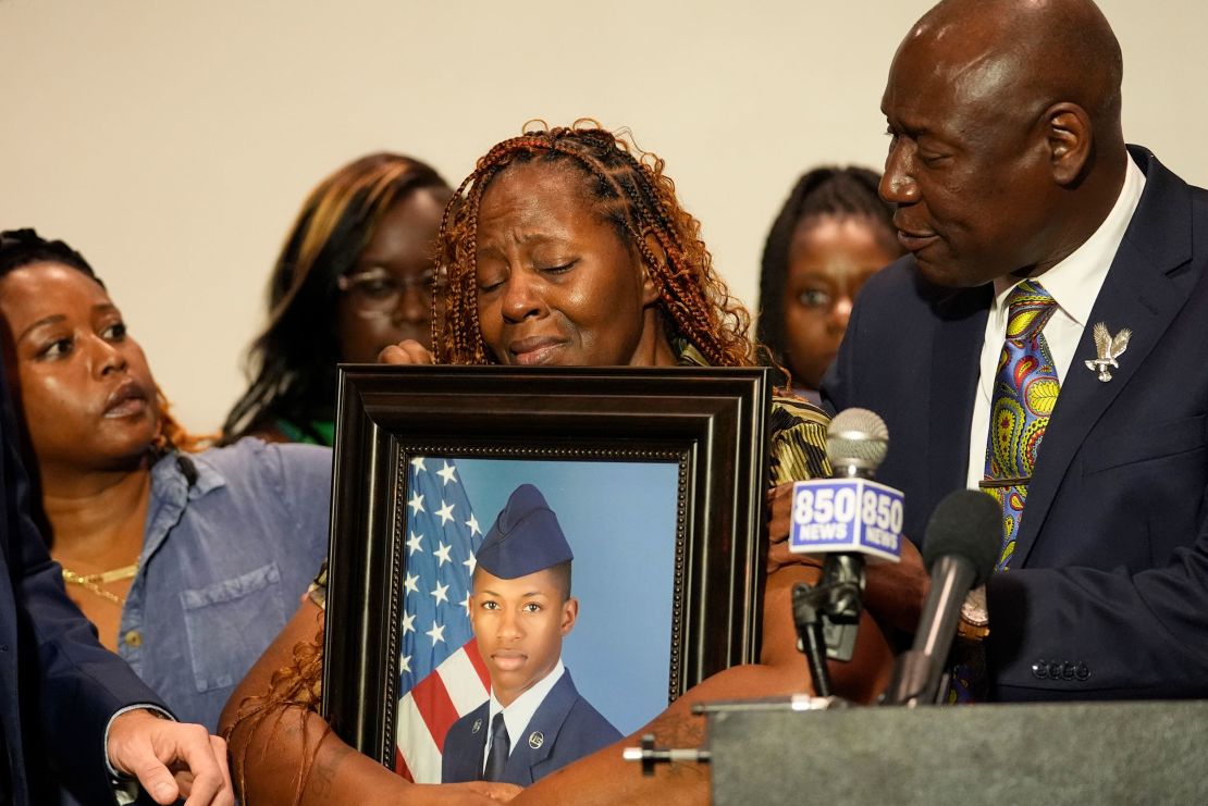 Roger Fortson's mother holds up a photo alongside family attorney Ben Crump (right) at a news conference about his death Thursday in Fort Walton Beach, Florida.