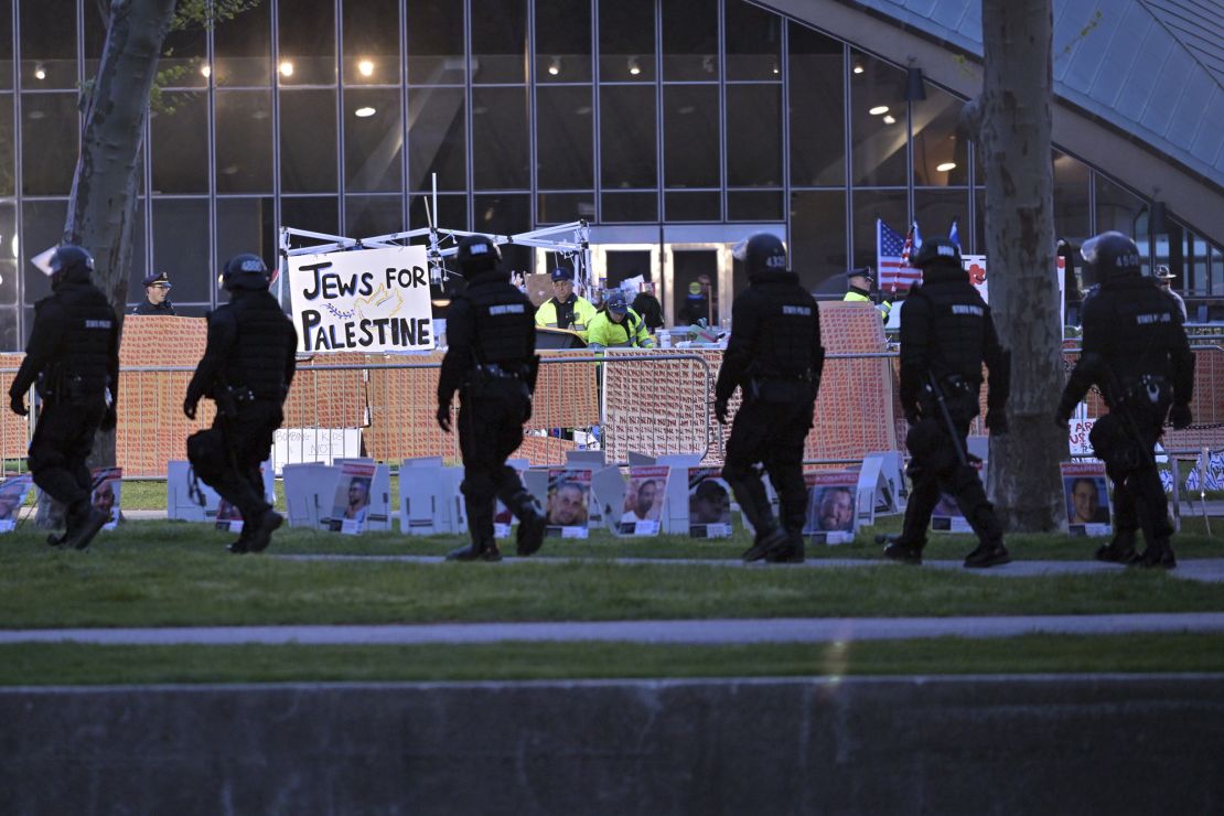 Police in riot gear walk past officers dismantling a pro-Palestinian encampment at MIT before dawn Friday in Cambridge, Massachusetts.<br />Josh Reynolds/AP
