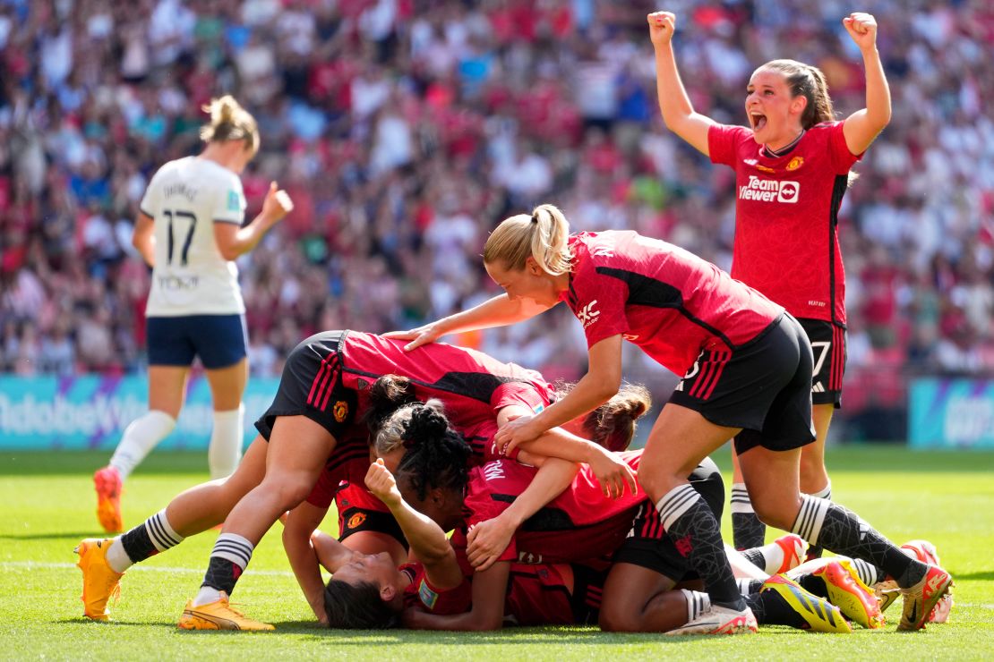 Rachel Williams, on the ground, was mobbed by her teammates after scoring United's second goal.