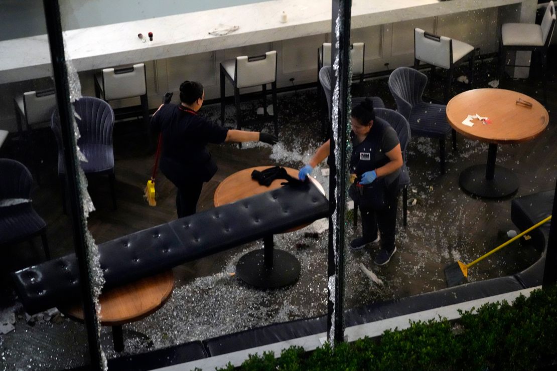 Workers clean up broken glass inside a damaged downtown restaurant after a severe thunderstorm Thursday in Houston.