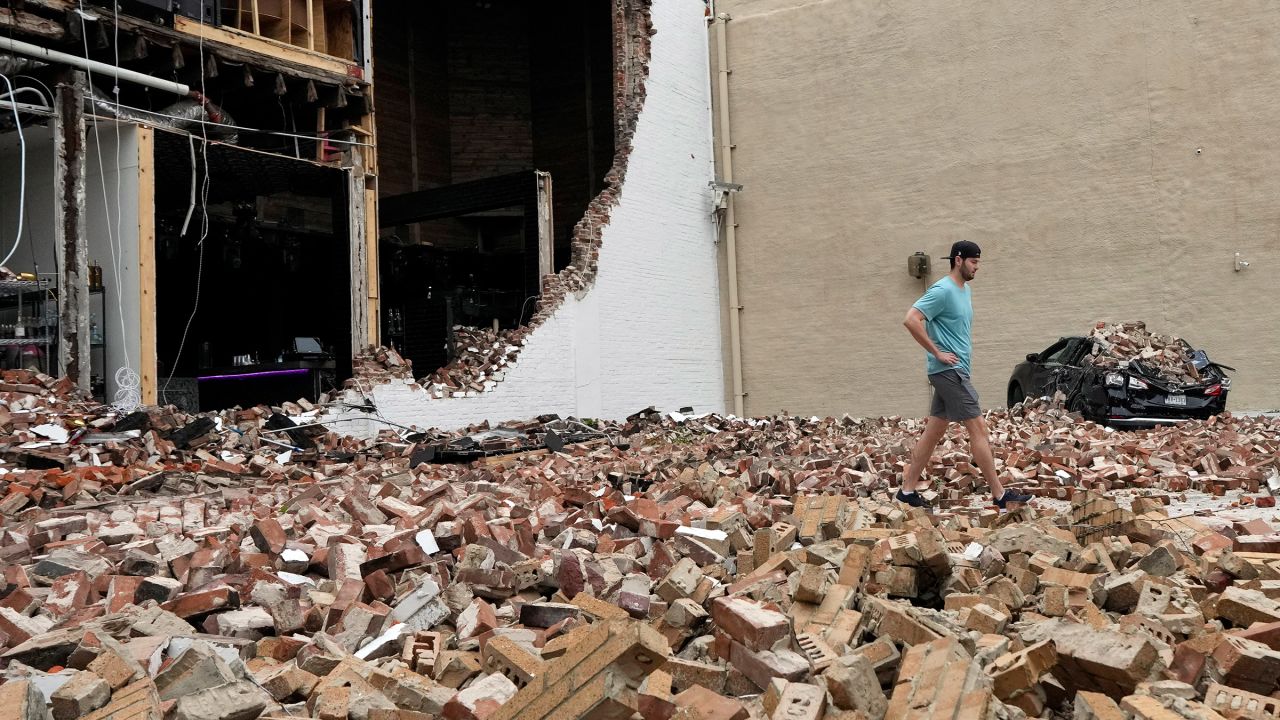 A man walks through fallen bricks from a damaged building in the aftermath of a severe thunderstorm in Houston on Friday, May 17, 2024. Thunderstorms pummeled southeastern Texas on Thursday, killing at least four people, blowing out windows in high-rise buildings and knocking out power to more than 900,000 homes and businesses in the Houston area.